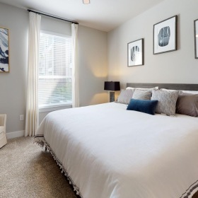 a bedroom with a bed and a dresser and a window