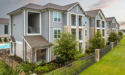 a multi story building with a lawn