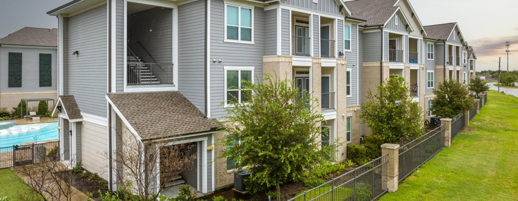 a multi story building with a lawn