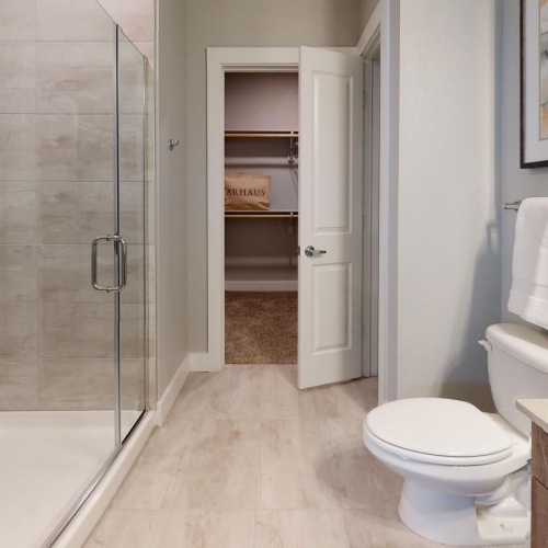 a bathroom with a glass shower stall and a toilet