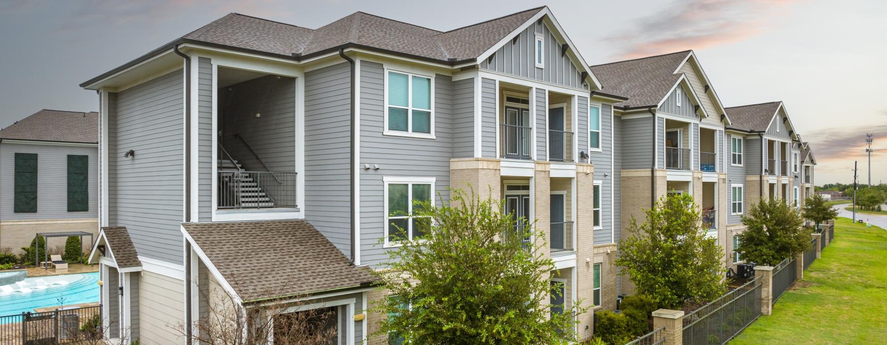 a multi story building with a lawn