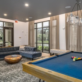 a lounge room with a pool table and couches